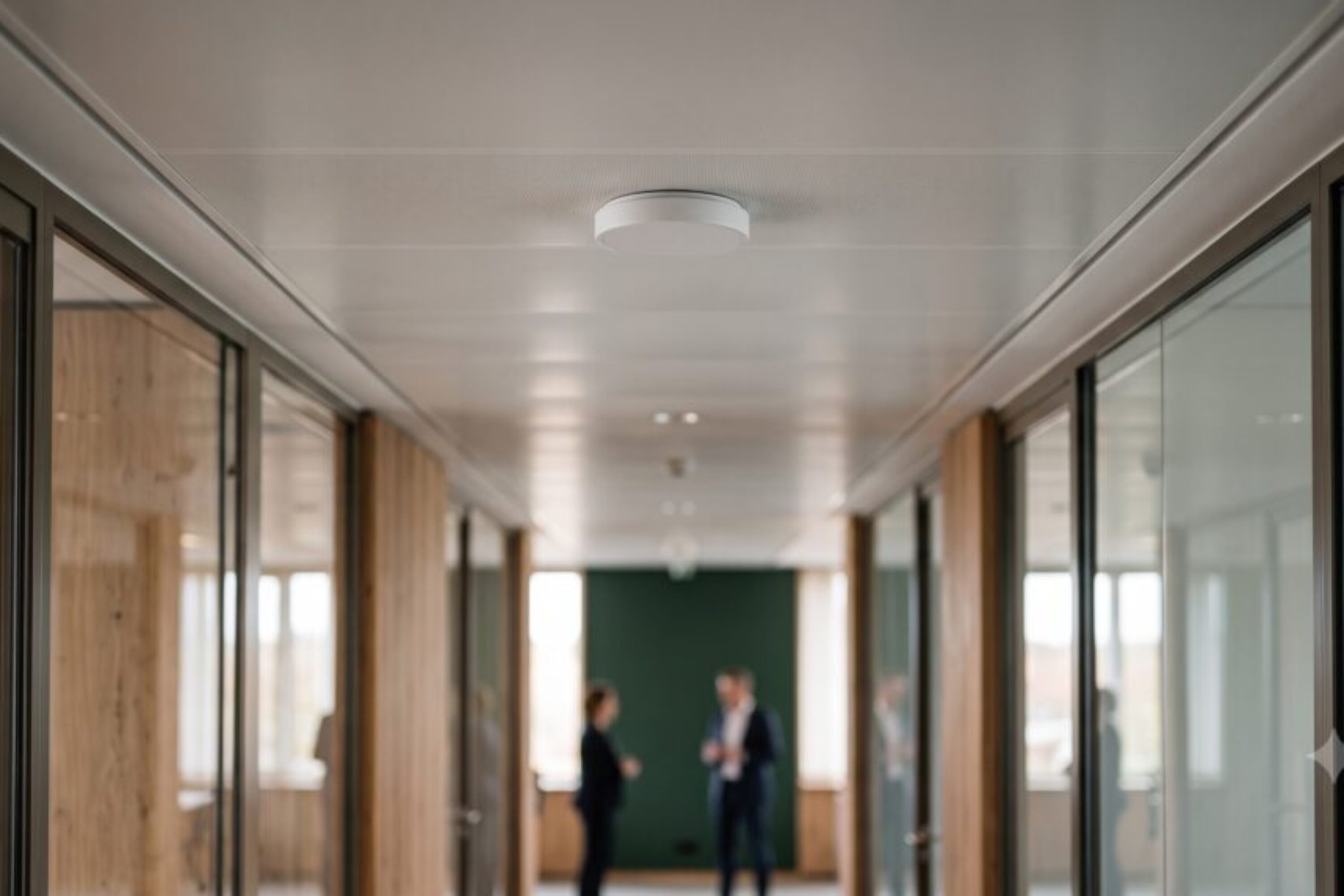 Small discreet radio unit on the ceiling of a modern office corridor
